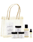 Starter Set by Sans Skincare – mini plant-based skincare essentials in a woven travel bag, includes cleanser, mask, scrub, serum, and butter