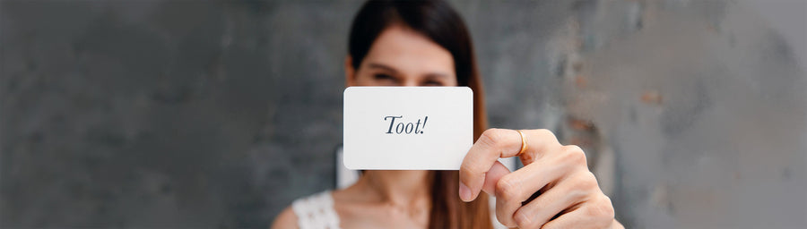 Woman holding up a card with the word toot written on it