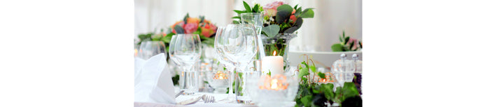 Elegant table setting with wine glasses, candles, and floral centerpieces for a formal dinner or celebration