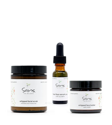 Sans Skincare Fall Renewal Ritual set — featuring three products: Whipped Facial Scrub in a brown jar with black lid, Mavi Face Serum in an amber glass bottle with a black dropper, and Whipped Face Butter in a smaller brown jar. Displayed against a clean white background, highlighting the minimalist, natural aesthetic of the brand.
